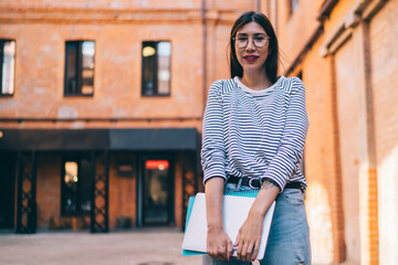  looking at camera during leisure outdoors, millennial female student