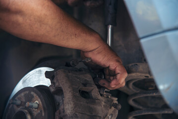 Close up Car Mechanic man hands repairing car auto repair shop. Man hands fixing machinery vehicle mechanical service. open vehicle hood checking up auto mobile. Vehicle Car maintenance engineer.