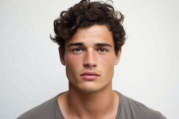 Portrait of a handsome young man with curly hair looking at camera