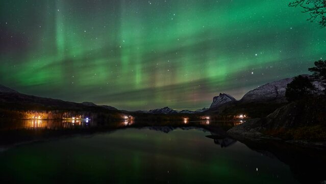 Aurora dancing with its reflection in an autumn landscape