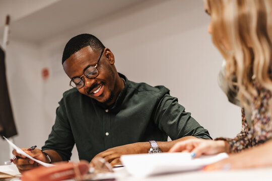 Happy, smiley, satisfied male manager reading positive statistics and reports.