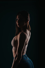 Confident Fit Woman Showing Progressive Body Transformation in Dark Studio