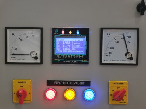 Image of selector switch and pilot lamps with digital meter on electrical cabinet.