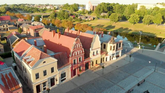 Beautiful aerial view of the Old Market square in Kedainiai, one of the oldest towns in Lithuania. Unique colorful Stikliu street houses in golden sunset light. Kedainiai, Lithuania.