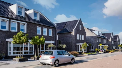 Fotobehang Dutch Suburban area with modern family houses, newly build modern family homes in the Netherlands, dutch family house in the Netherlands, newly build street with modern house © Fokke Baarssen