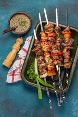 Bbq grilled meat pork, chicken and vegetable skewers on tray. Top view, flat lay. Blue background