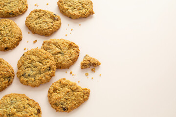 Closeup top angle view of oatmeal raisin cookies on light pink background with copy space