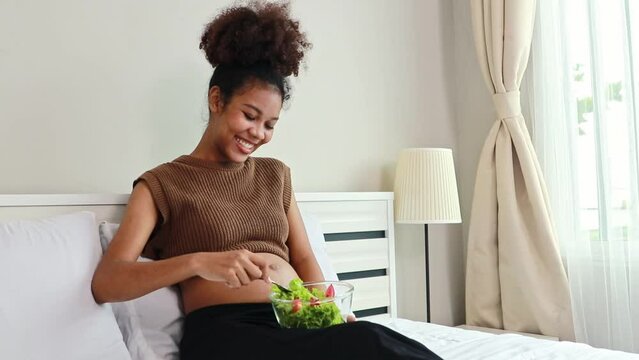 Young mother Thai-African descent eats healthy salad with vitamins and minerals. Vegetables that are beneficial to the body pregnant women and add nutrition to boost the health immunity of the fetus.
