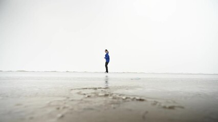 Caucasian woman in a blue sweater is skating on a frozen lake. The figure skater performs the program.