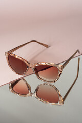 sunglasses on pink and mirror background