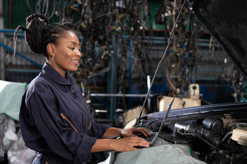 mechanic using laptop computer for checking and fixing a car in automobile repair shop