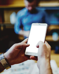 Faceless man watching cellphone at office space