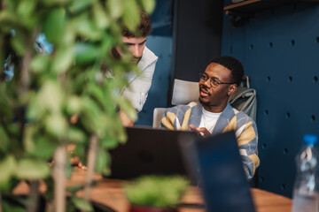 Multiracial people in a creative co work space. Experienced entrepreneurs gather market research in...