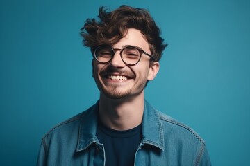 Cheerful young man in eyeglasses looking at camera