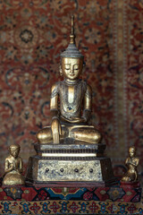 Metal statue of a seated Buddha meditating or praying