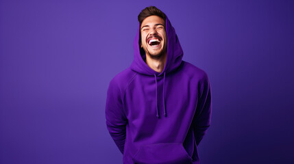 Ultra handsome Caucasian, smiling and laughing, wearing purple hoodie. Bright purple solid background similar to the dress color.