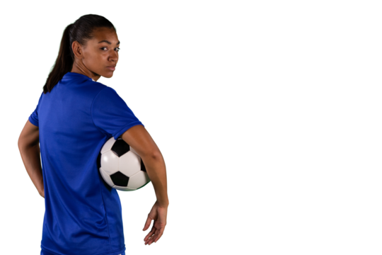 Digital png photo of serious biracial female footballer with ball on transparent background
