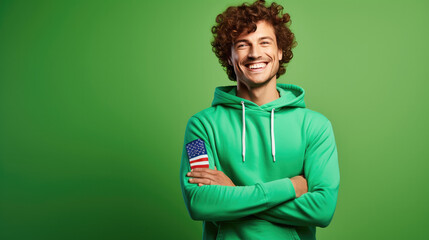 Ultra handsome man with curly hair, smiling and laughing, wearing a solid deep green sweatshirt. deep solid green background similar to the dress color.