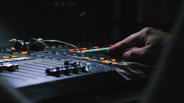 The professional tool for sound engineers in the studio or on stage. Digital music mixer for sound control. Close-up. A man's hands reacting to live sound