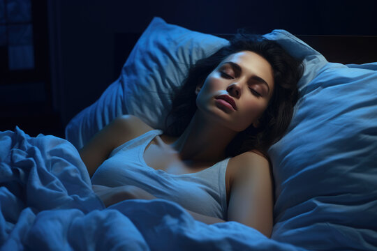 Woman laying in bed with her eyes closed. This image can be used to represent relaxation, sleep, rest, or peaceful moment.