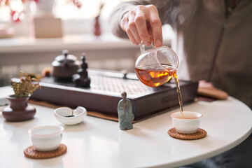 Tea master pours white tea to guests. Everything is ready for the tea ceremony. The ceremony is according to all the rules, but not in the classical style. Adapted to a modern apartment.