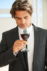 Glass of red wine, glass and man with promotion, thinking and celebration with event, aroma and suit. Rich, guy and expert with alcohol, idea and luxury with beverage, drink and winery with scent