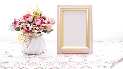 Photo frame with artificial flowers , Empty frame for letter with pink orange rose flowers background ,vintage style copy space ,romantic tone 
