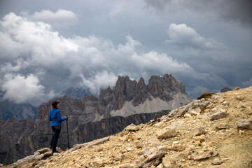 Fototapeta premium Woman traveler traveling alone in breathtaking landscape of Dolomites Mounatains. Travel lifestyle wanderlust adventure concept.