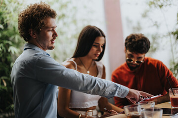 Architects, engineers, and executives discuss a blueprint and project details at a coffee bar, collaborating on successful construction planning and real estate investment outdoors.