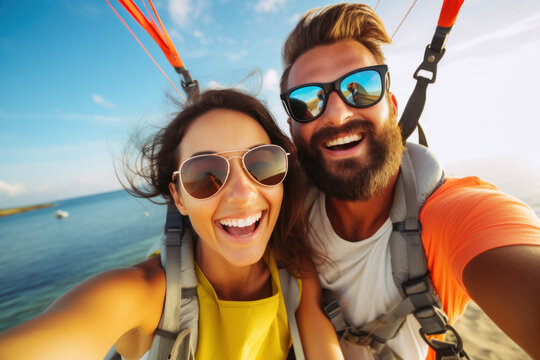 Joyful couple parasailing over a serene beach horizon.