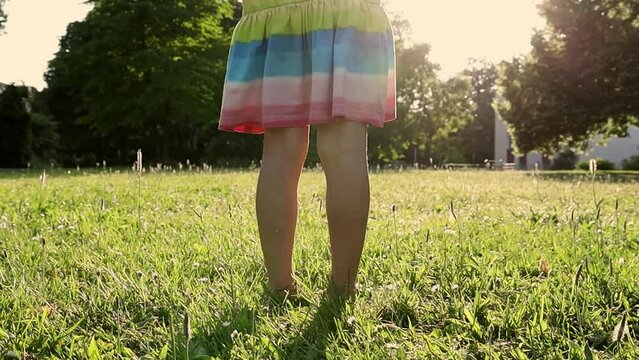Little girl runs through the meadow in the park.