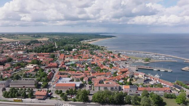 Aerial sideways over small city Simrishamn in Sweden on a sunny cloudy day