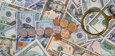Magnifying glass above dollars background