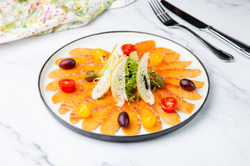 Pieces of smoked red trout with tomatoes, feta cheese, herbs. Mediterranean appetizer, top view