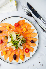Pieces of smoked red trout with tomatoes, feta cheese, herbs. Mediterranean appetizer, top view