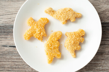 A top down view of a plate of dinosaur chicken nuggets.