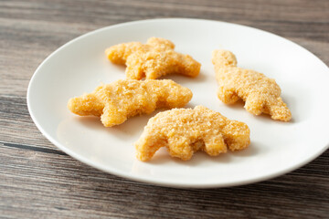 A view of a plate of dinosaur chicken nuggets.