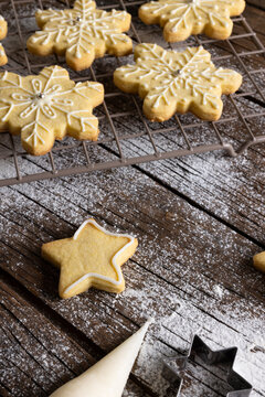 Vertical image of close up of christmas cookies with flour and copy space on wooden background