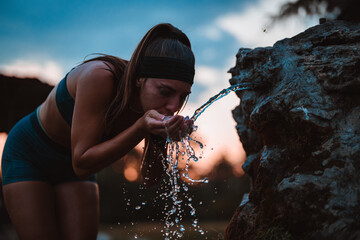 Active Woman Refreshes with Water After Strenuous Training in Beautiful Park