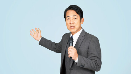 マイクを持って案内するミドル男性