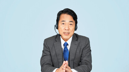 ヘッドセットをつけて話すミドル男性