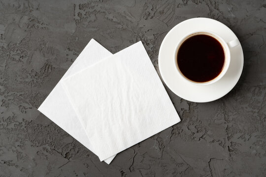 Top view of coffee cup and paper napkins on gray background