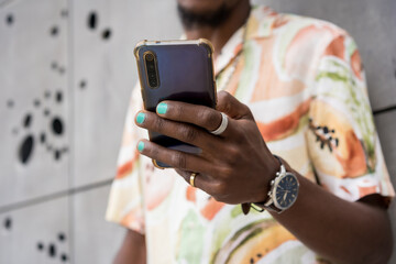 Hand of a man with painted nails using phone