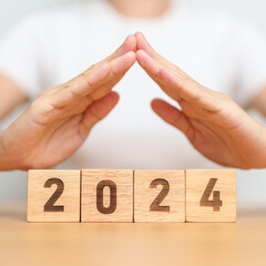 hand cover 2024 Year block. Insurance, protection, safety and New year holiday Concepts