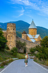 a traveler walks along the road leading to the Ananuri monastery in Georgia