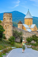 a traveler walks along the road to the Ananuri monastery, Georgia