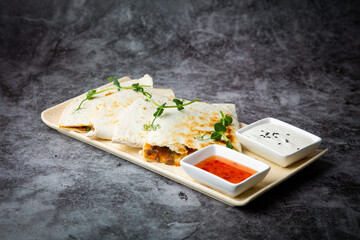 crispy flatbreads stuffed with meat, herbs, lime and two sauces, side view
