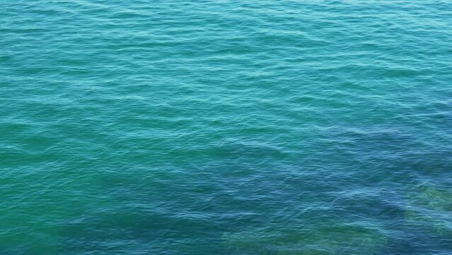 Blue ocean water with calm waves and underwater stones