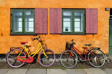 Foto op Plexiglas Bicycles in front of an orange house facace in Nyboder (historic row house district of former Naval barracks in Copenhagen, Denmark). © Tommy Larey