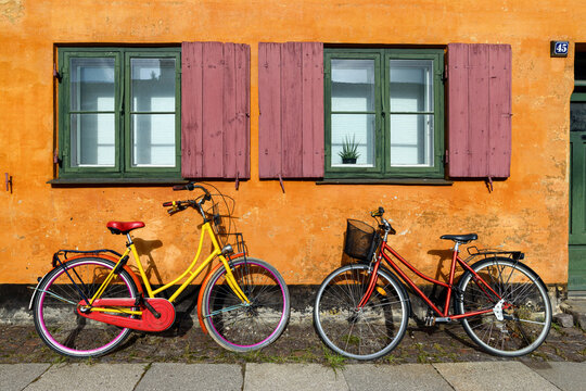 Bicycles in front of an orange house facace in Nyboder (historic row house district of former Naval barracks in Copenhagen, Denmark).